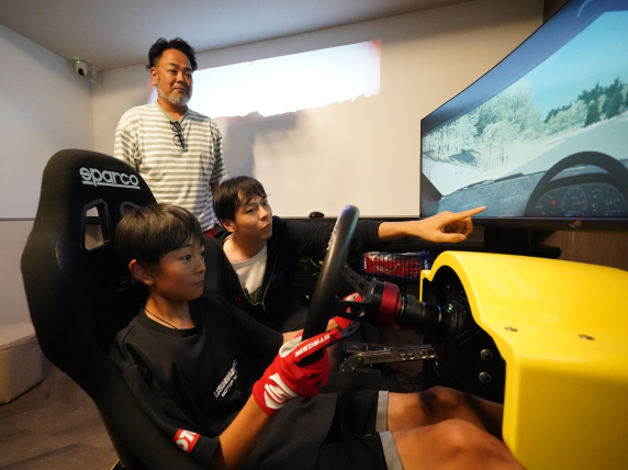 子どもたちがレーシングシミュレーターを利用するイメージ
